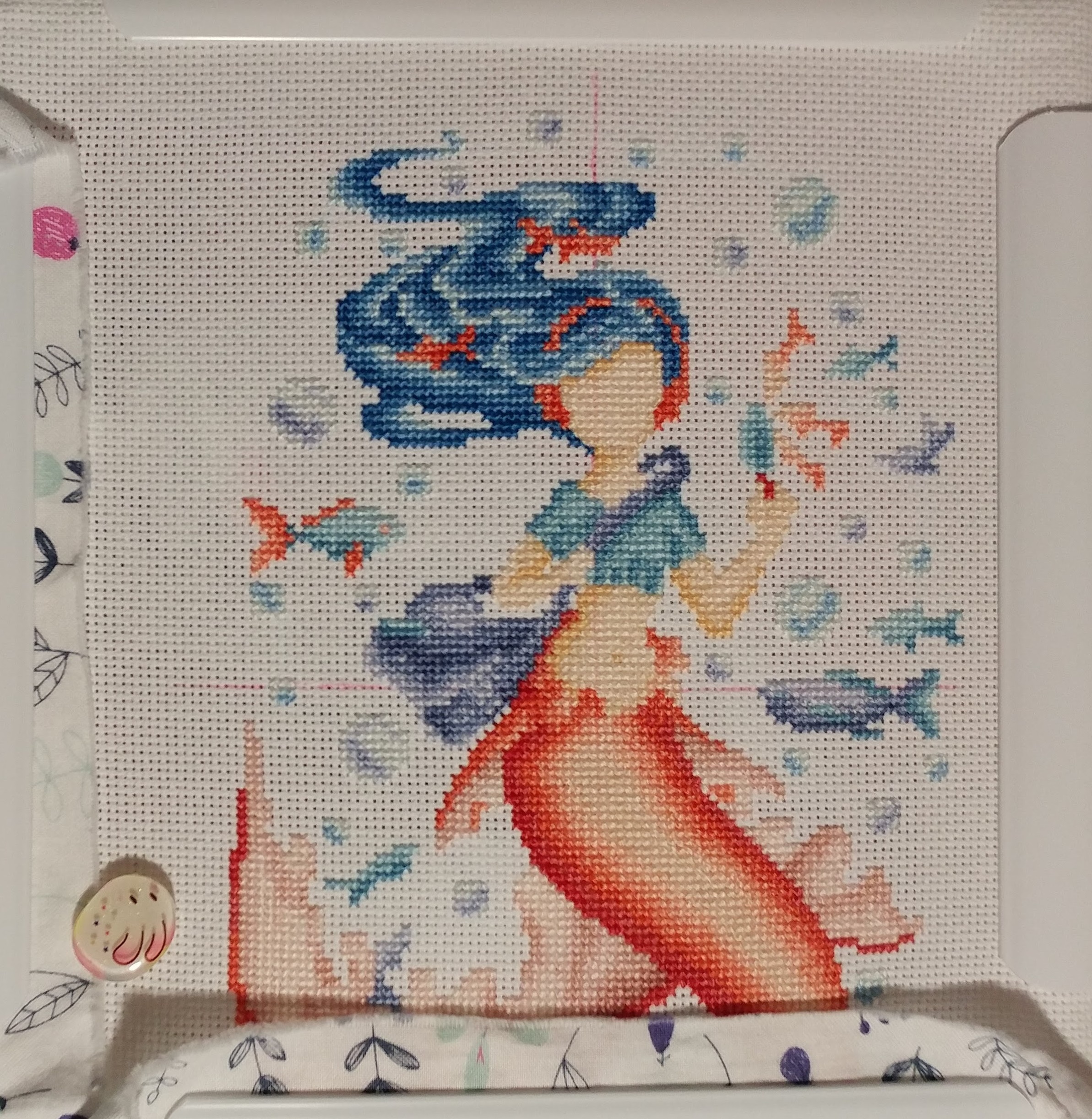 The same mermaid cross stitch, but with no backstitching, and still in the working embroidery frame